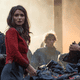 Marian (Eve Hewson) sporting one of her many unusual clothing choices. Also, that guy on the left is wearing a knit beanie and a hoodie.